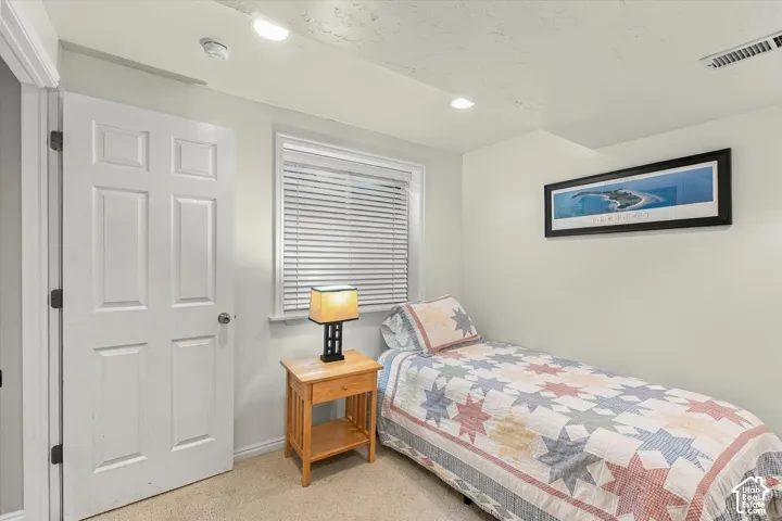 Neutral-toned interior featuring recessed lighting, a multi-panel interior door, and a window equipped with horizontal blinds