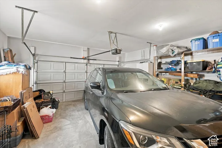 Garage featuring a concrete floor, sectional overhead door, and mechanical garage door opener