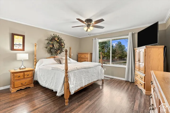 Room featuring wood-finish flooring, a ceiling fan with integrated lighting, and a large window