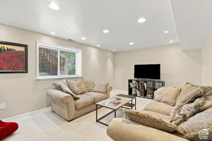 Neutral wall palette with recessed lighting and a sliding window featuring horizontal blinds