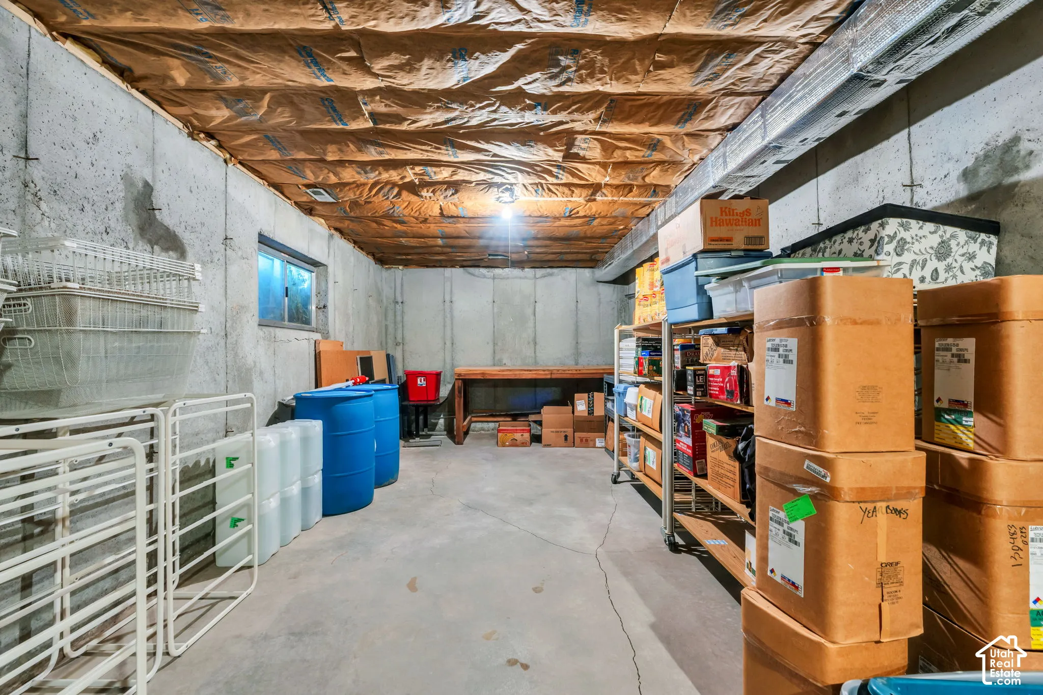 Unfinished utility space featuring exposed concrete walls, concrete flooring, and insulated ceiling joists