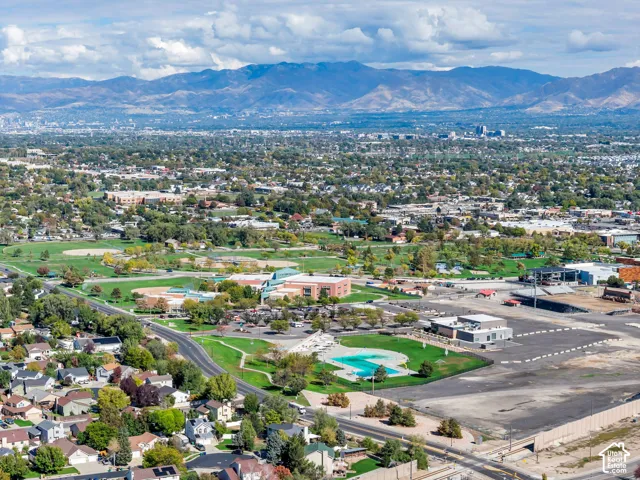 Aerial perspective featuring a prominent mountain backdrop, sprawling municipal park grounds, baseball fields, and a community swimming pool