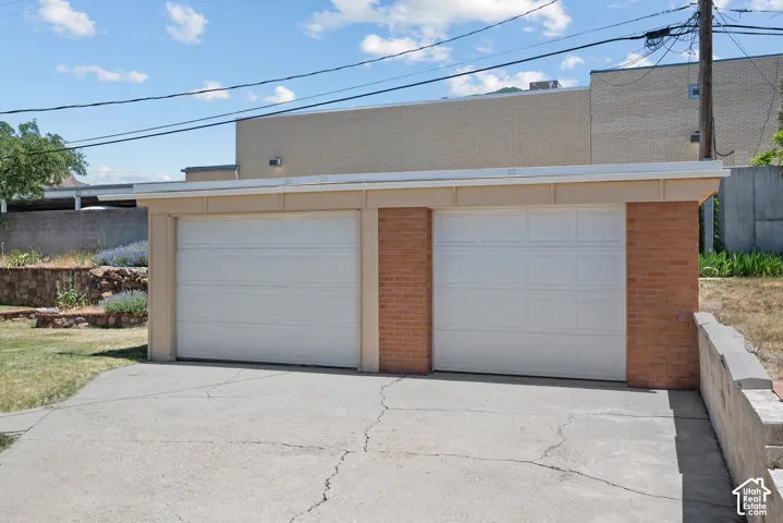 Detached two-car garage featuring brick pillar construction and white paneled garage doors