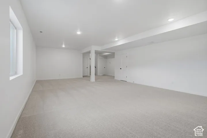 Open-concept interior space featuring wall-to-wall carpeting, recessed ceiling lighting, and neutral-toned wall paint