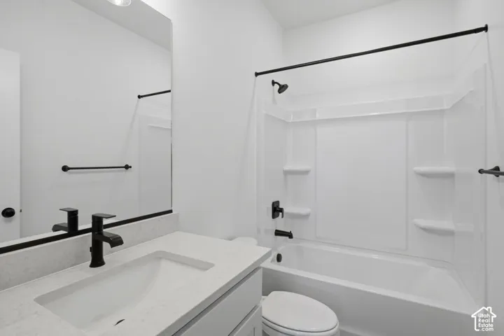 Bathroom featuring a vanity with a stone-finish countertop, undermount sink, and matte black faucet