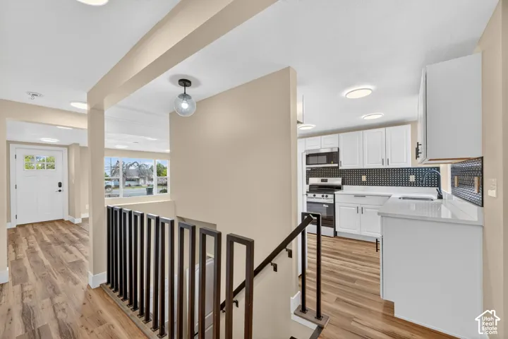 Kitchen featuring white shaker-style cabinetry, solid-surface countertops, and a decorative tile backsplash