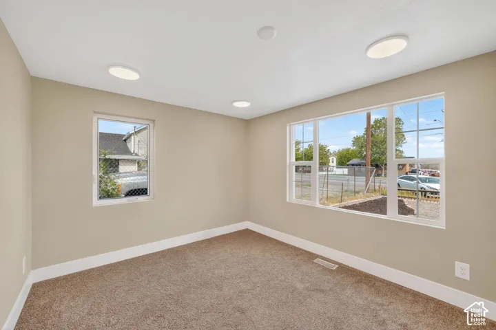 Neutral-toned walls, plush wall-to-wall carpeting, recessed ceiling lighting, and multi-pane windows