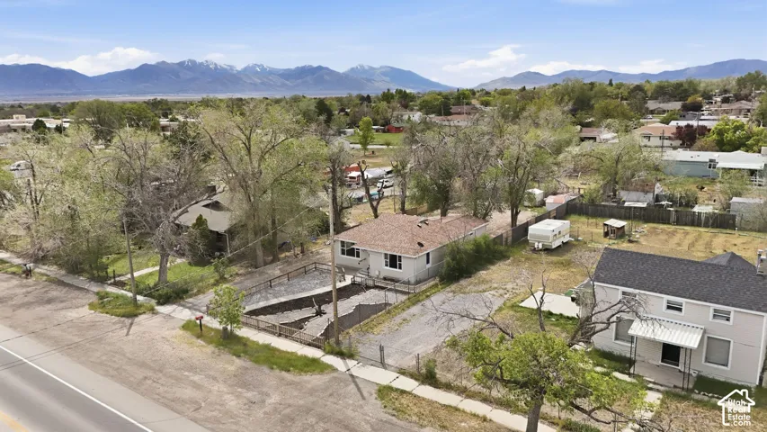 Single-story residence featuring a shingled roof, neutral-toned exterior, and mountain backdrop
