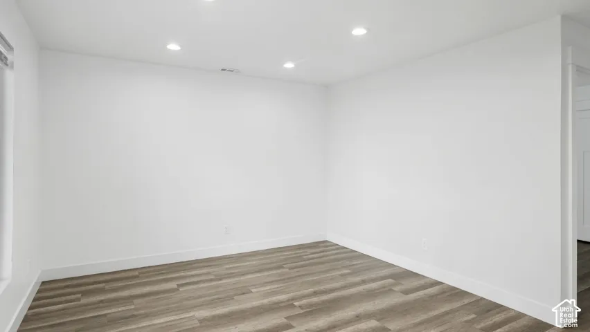 Neutral room featuring wood-finish flooring and recessed lighting