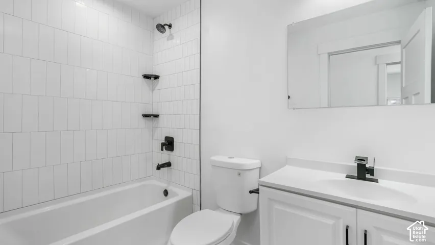 Bathroom featuring white vertical subway tile shower surround, matte black plumbing fixtures, built-in corner shower shelving, white shaker-style vanity, and a rectangular mirror