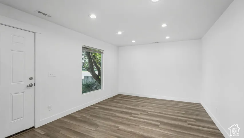 Interior room featuring wood-finish flooring, recessed lighting, and a single-pane window