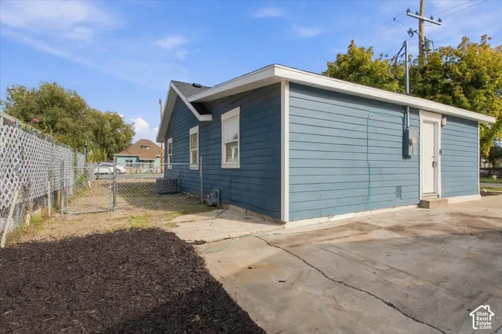 Blue lap siding exterior, concrete driveway, and chain-link fencing