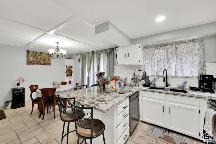 Kitchen featuring stone-finish countertops, white cabinetry, subway tile backsplash, matte black faucet hardware, and tiled flooring