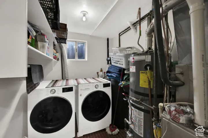 Utility room featuring built-in shelving, a dedicated laundry area, a water heater, and a furnace