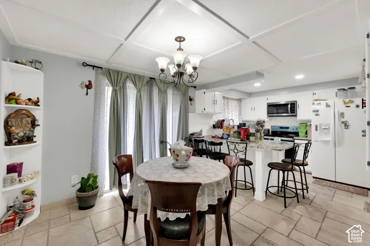 Kitchen featuring stone-finish countertops, a breakfast bar, coffered ceiling, stone-tile flooring, and built-in corner shelving