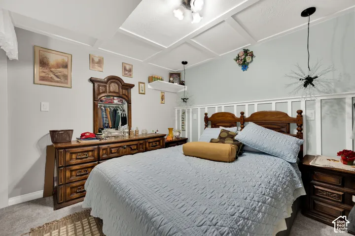 Coffered ceiling with integrated lighting, wall-mounted floating shelving, and board-and-batten wainscoting