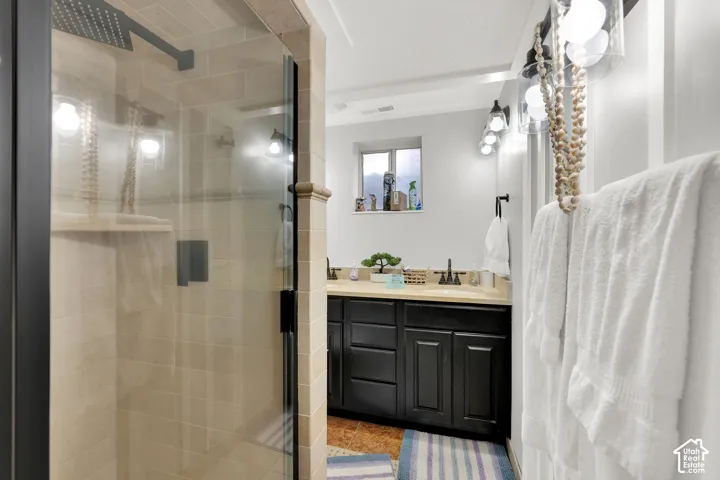 Walk-in shower with floor-to-ceiling tile, black frame glass enclosure, and matte black rainfall showerhead