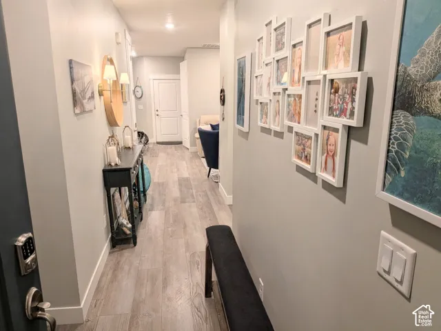 Entryway featuring wood-finish flooring, neutral wall tones, recessed lighting, and a six-panel door