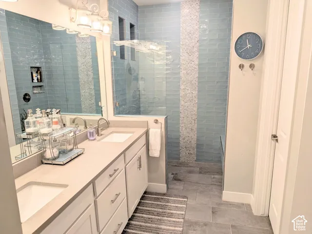 Double vanity featuring a light-toned countertop, under-mount sinks, and white shaker-style cabinetry