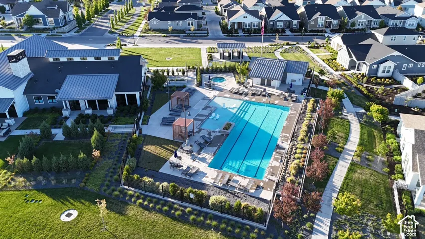 Community recreation area featuring a lap pool, integrated spa, concrete deck, and covered poolside structures