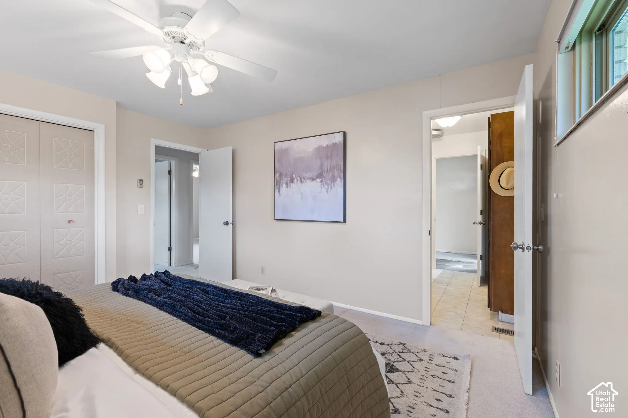 Room featuring a ceiling fan with integrated lighting, neutral wall paint, and closet doors with square decorative paneling