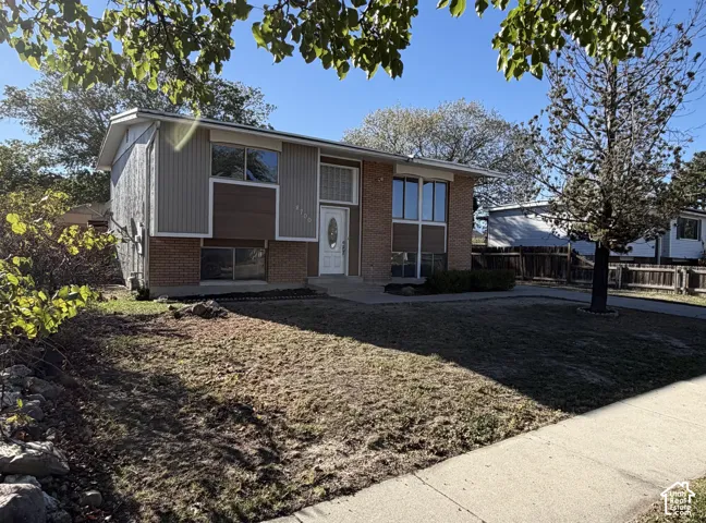 Split-level exterior featuring a brick and vertical siding facade, multi-pane windows, and a central entryway