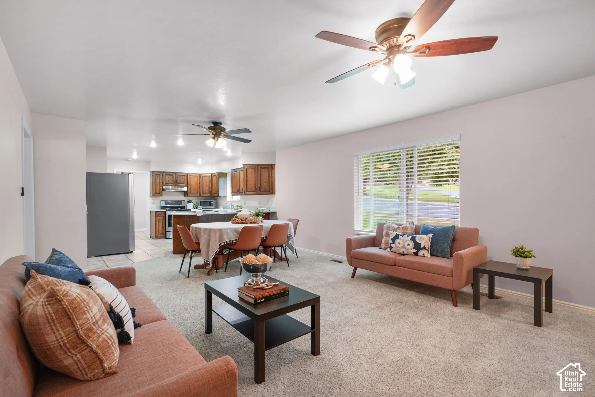 Open-concept living space featuring wood-finish ceiling fans, recessed lighting, and wall-to-wall carpeting