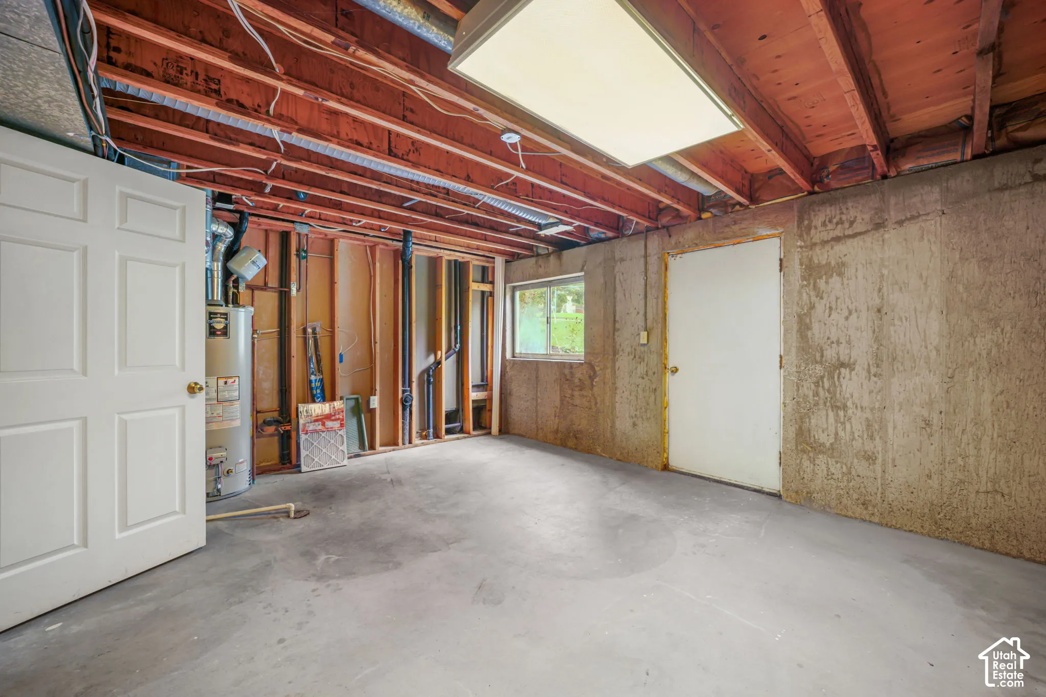 Unfinished utility space with exterior entrance. Area plumbed for a future kitchenette.