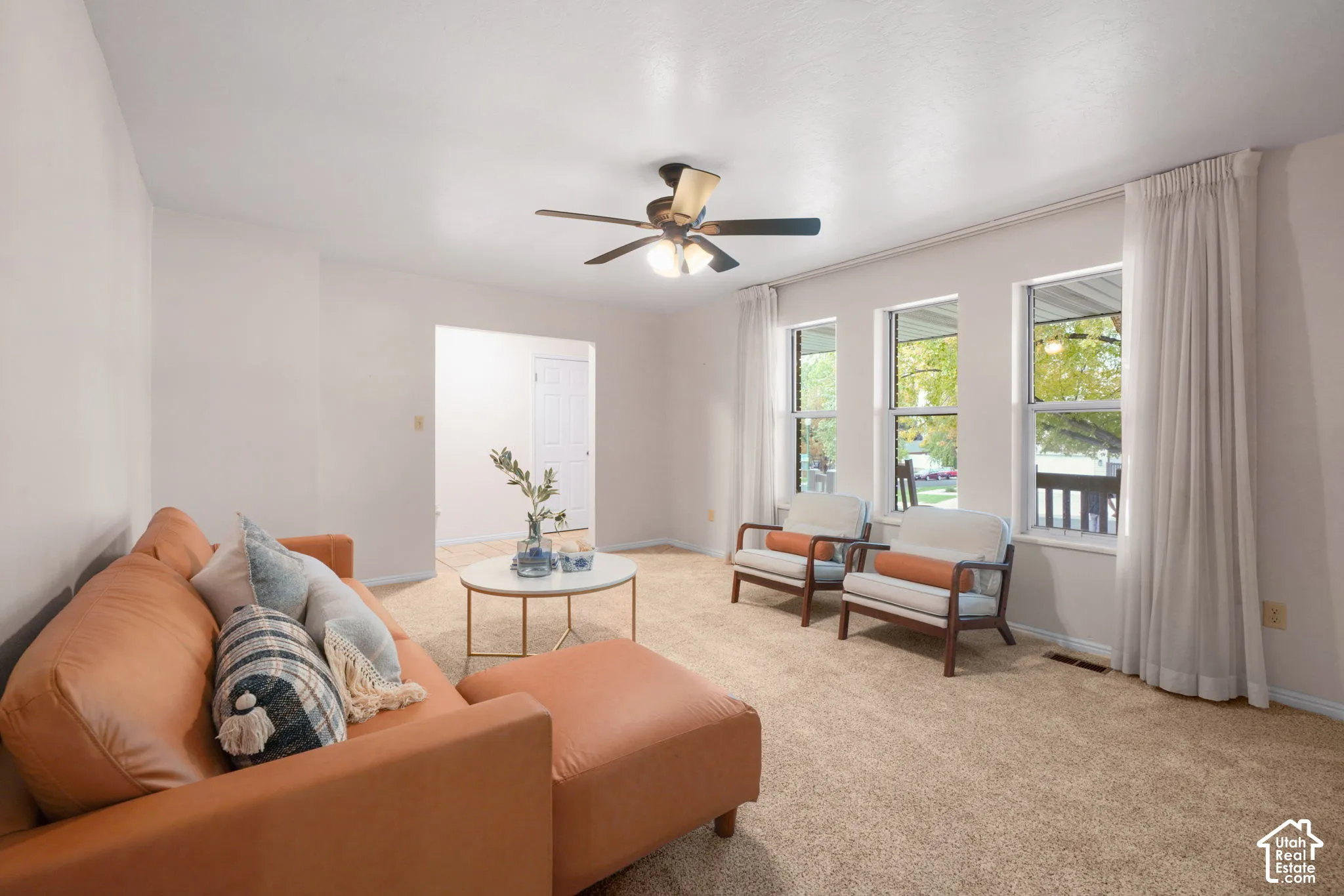 Living room with natural light, carpeted floors and ceiling fan