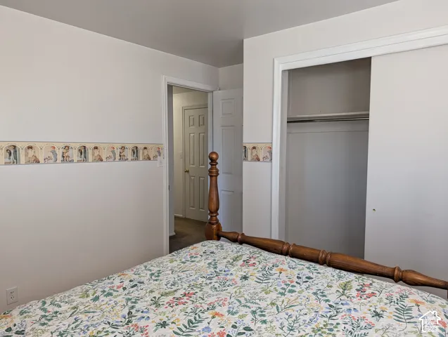 Room featuring a sliding door closet with built-in shelving, decorative wallpaper border, and white paneled interior doors