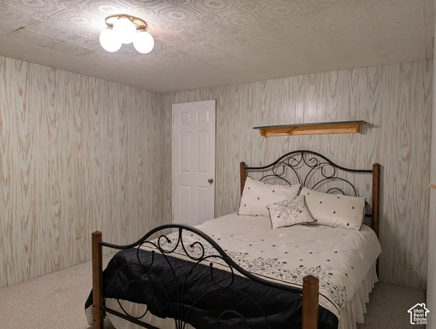 Textured ceiling featuring a geometric pattern, wood-finish paneling, and a built-in wall-mounted display shelf