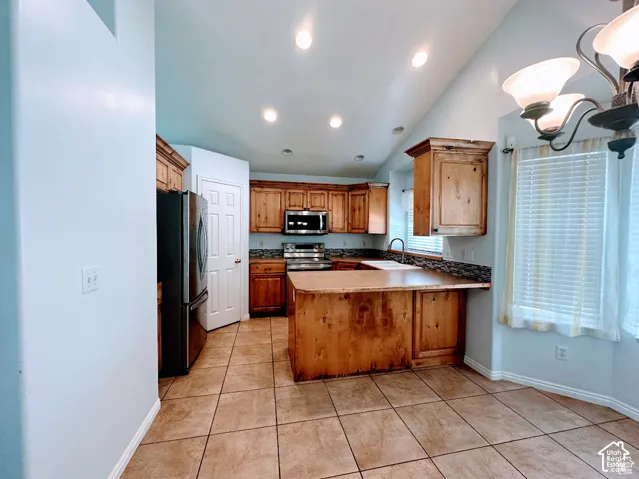 Kitchen featuring stained wood cabinetry, a center island with a wood countertop, recessed ceiling lighting, tile flooring, and a multi-toned mosaic tile backsplash