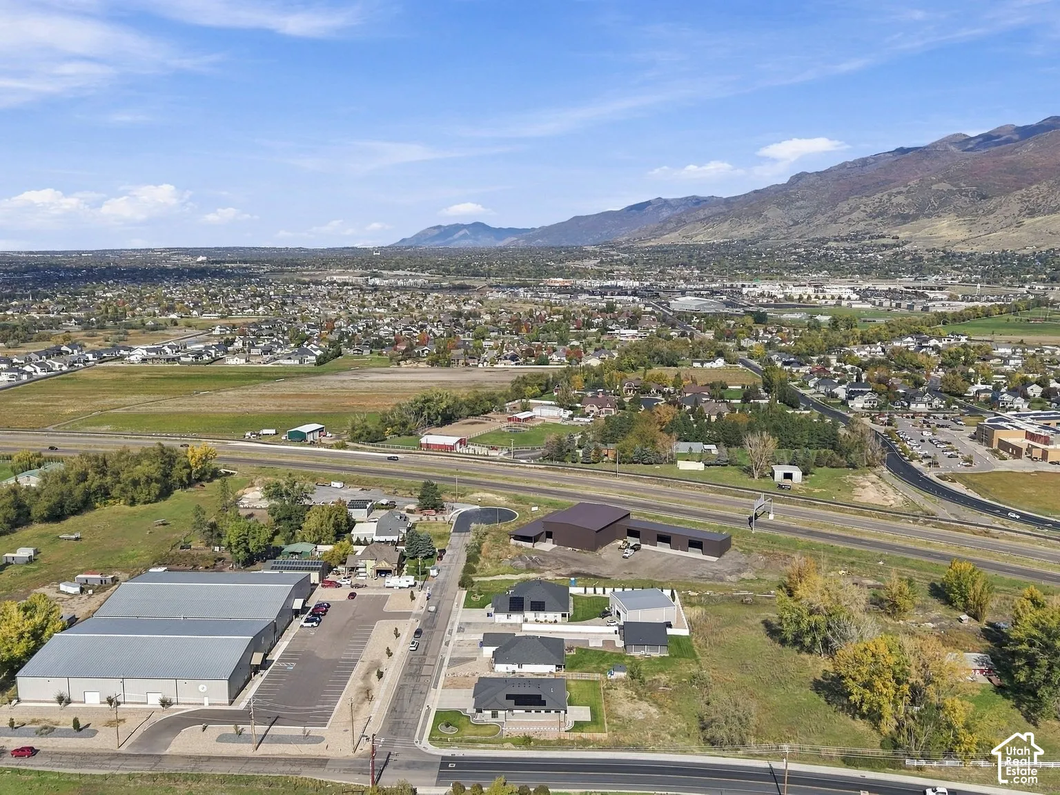 Aerial view featuring expansive acreage, mountain backdrops, and proximity to major thoroughfares
