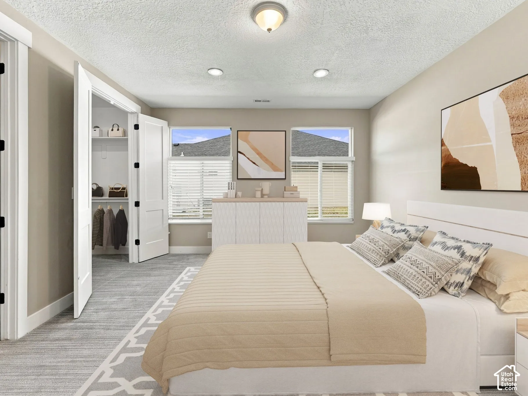 Spacious room featuring neutral wall tones, recessed lighting, dual-pane windows, and a walk-in closet with double-door entry