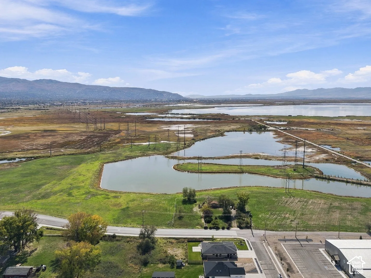 Aerial perspective featuring expansive acreage, natural water features, and mountain topography