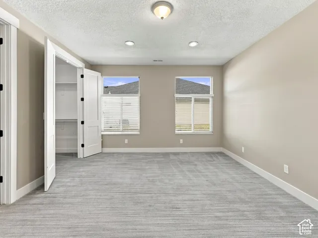 Room featuring neutral-toned wall paint, recessed lighting, carpeted flooring, and double-door closet storage