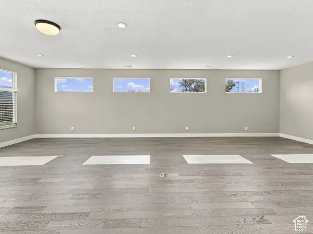 Neutral-toned interior featuring wood-finish flooring, recessed lighting, a flush-mount light fixture, and horizontal clerestory windows