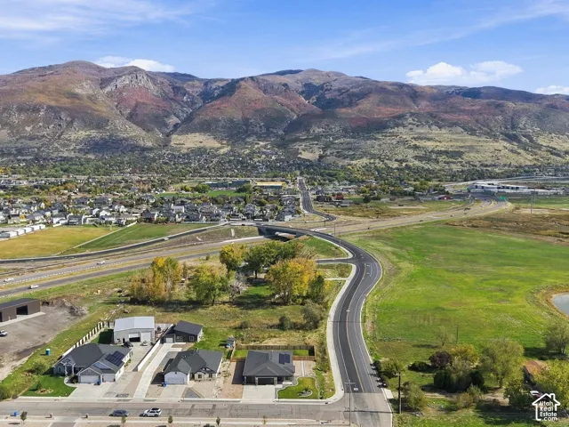 Aerial perspective featuring expansive mountainous surroundings, open green space, and proximity to regional thoroughfares