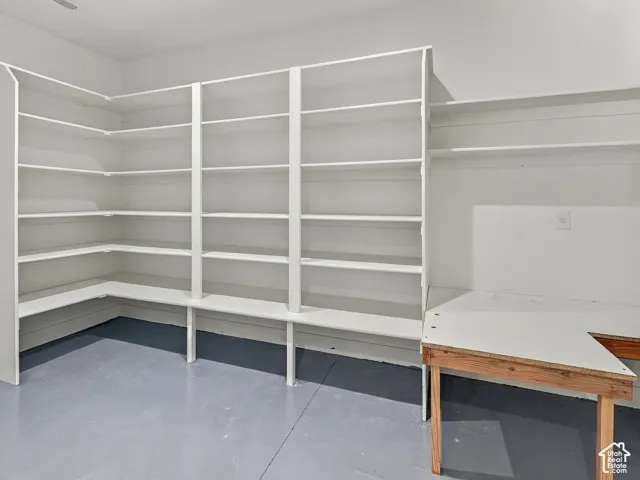 Built-in white shelving units featuring extended wall-to-wall storage and a flat-surface workspace