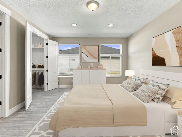 Spacious room featuring neutral wall tones, recessed lighting, dual-pane windows, and a walk-in closet with double-door entry