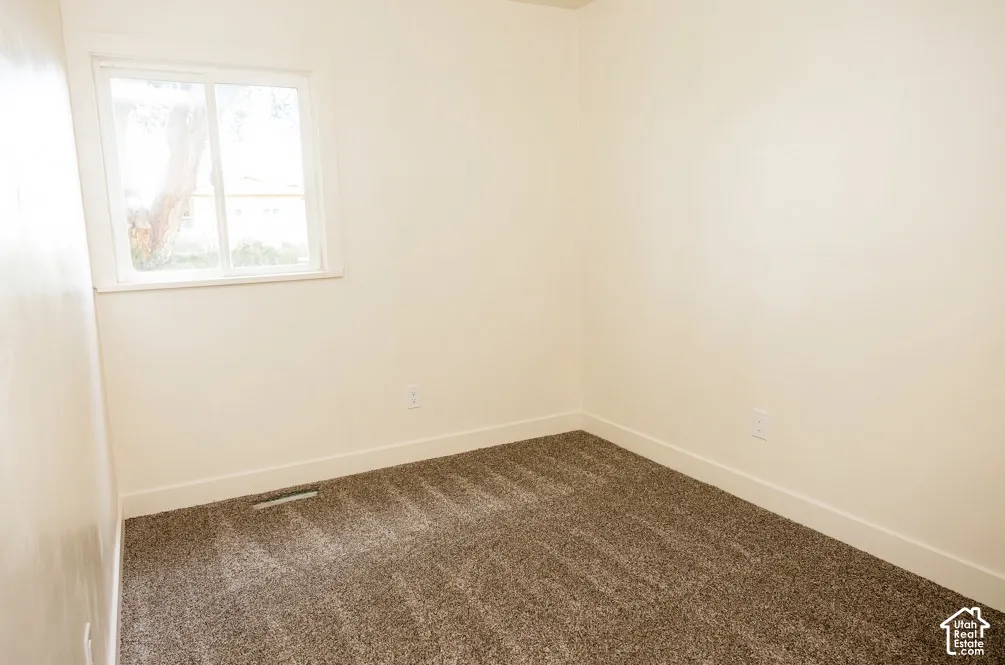 Neutral interior room with carpeting and a single sliding window