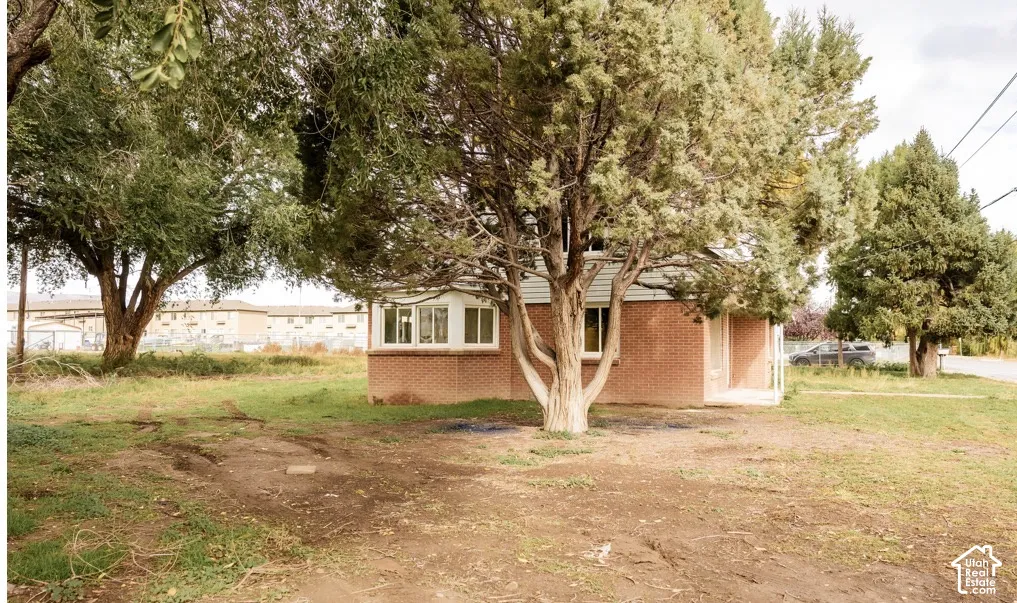Single-story residence featuring a brick exterior and large mature trees