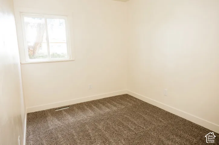 Neutral interior room with carpeting and a single sliding window
