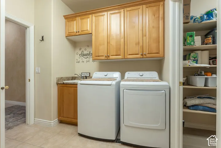 Laundry room featuring light-finish cabinetry, stone-surface countertop, integrated utility sink, and built-in shelving