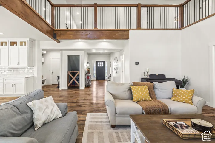 Open-concept interior featuring wood-finish flooring, a vaulted ceiling, and a prominent wood-beam accent