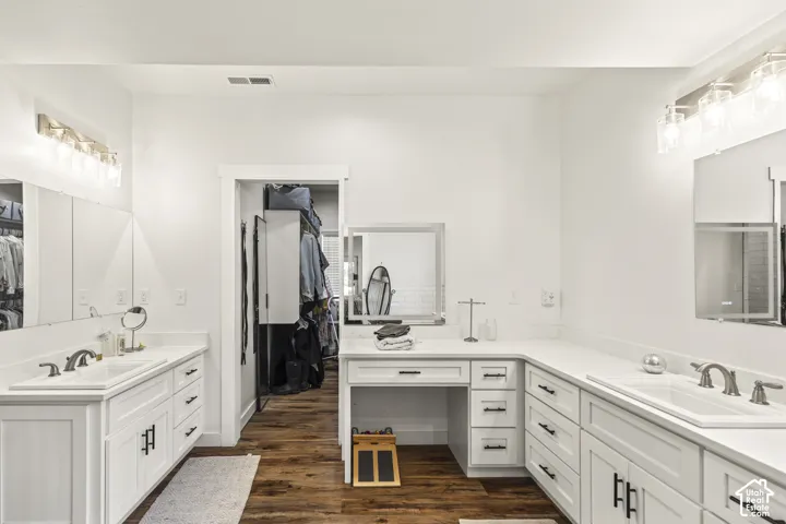 Double vanity featuring white cabinetry, solid surface countertops, dual undermount sinks, and matte black hardware