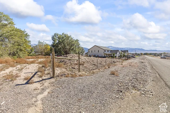 Expansive undeveloped parcel featuring mountain scenery, mature trees, and wire-and-post perimeter fencing