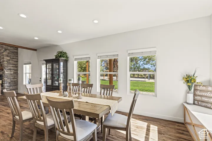 Dining space featuring wood-finish flooring, recessed lighting, and a floor-to-ceiling natural stone masonry accent wall