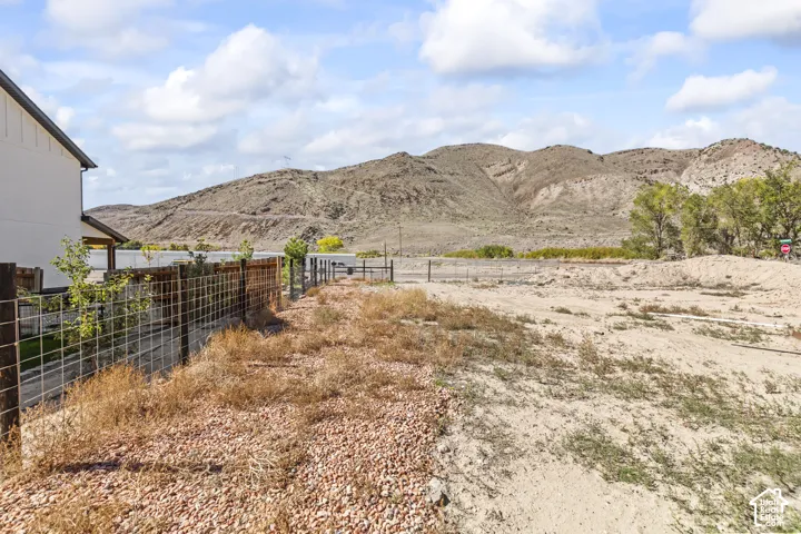 Expansive lot featuring rugged mountain terrain, natural landscape, and wire-mesh perimeter fencing
