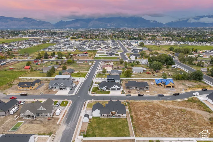 Aerial perspective of the residential development featuring paved street infrastructure, multi-lot layout, and mountain backdrops